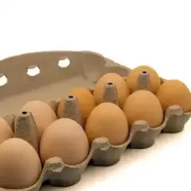 Fresh brown and white eggs in a wooden crate